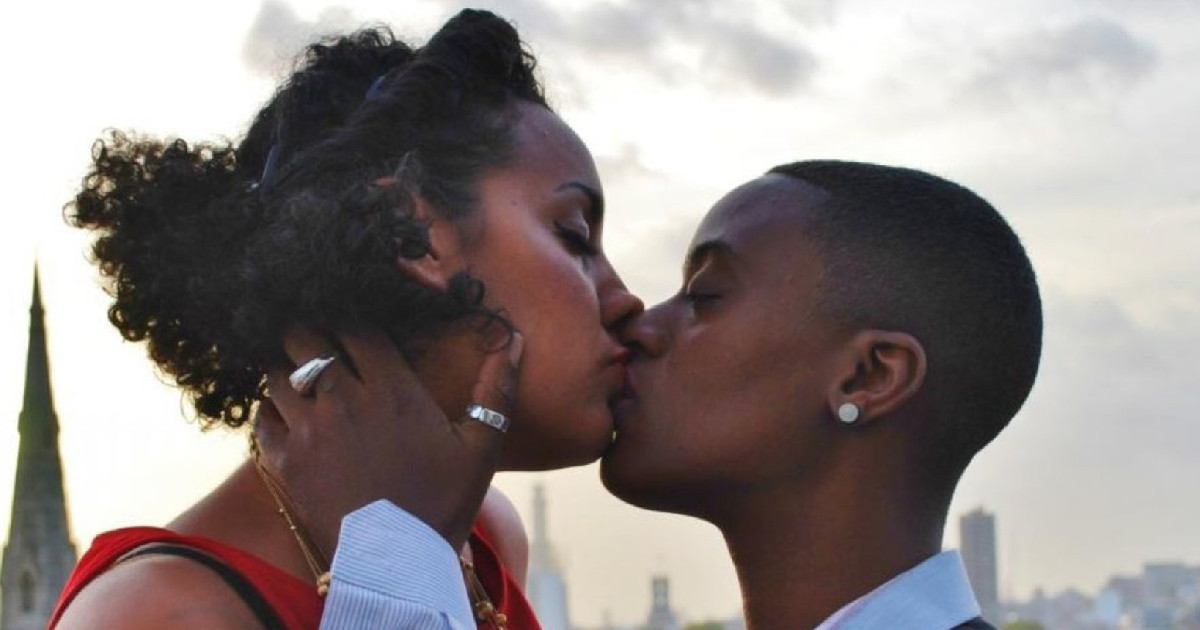 Two women kissing in the open air