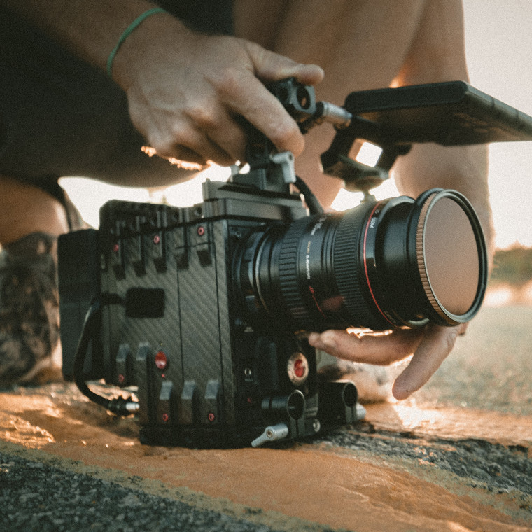 Person with a camera, positioned on the edge of a road