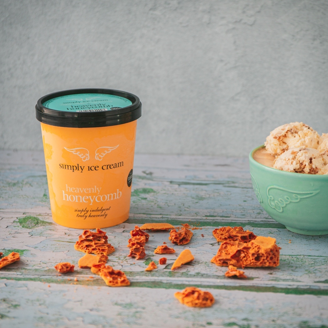 Honeycomb ice cream displayed on a table in flecks and in a pot