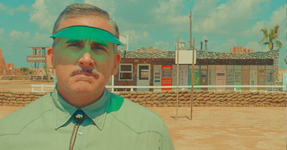 Man in cap in hot desert setting stares at camera