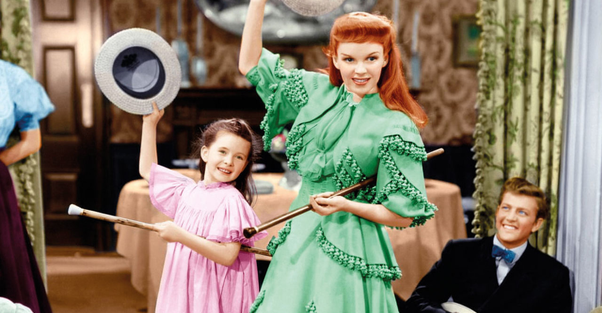 Judy Garland and small child dancing and singing in a house