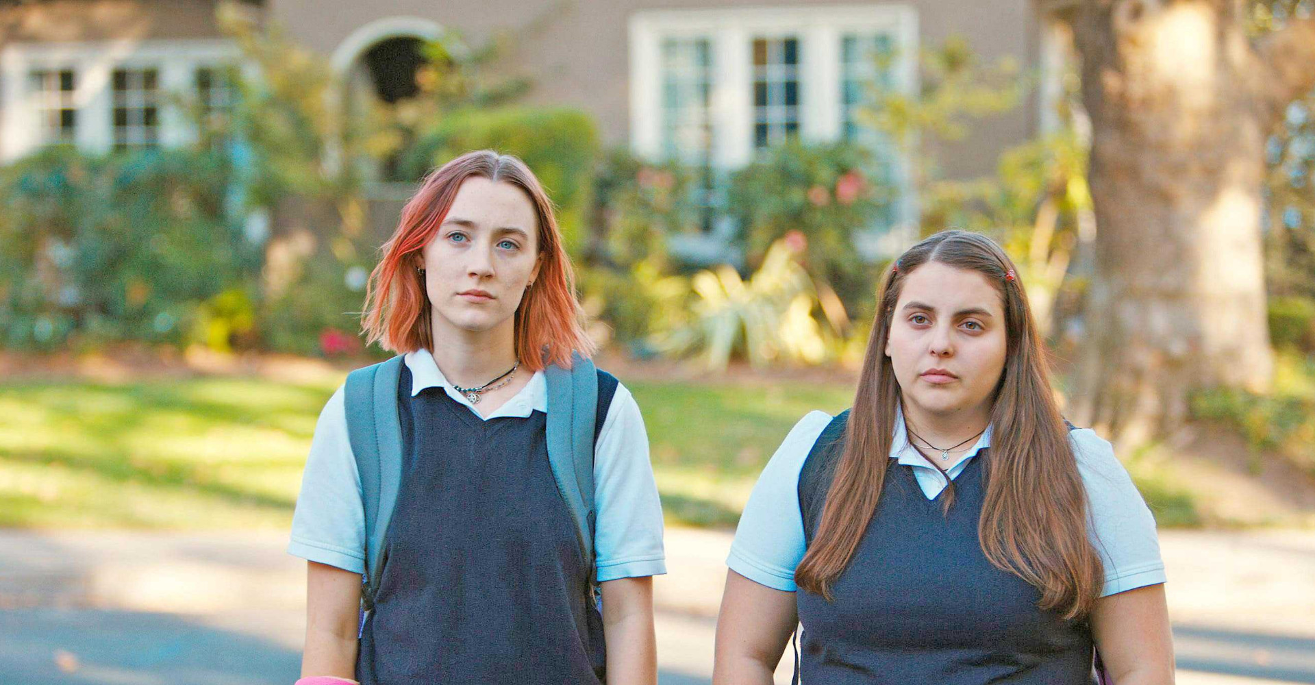 Two young women in school uniform looking mildly annoyed