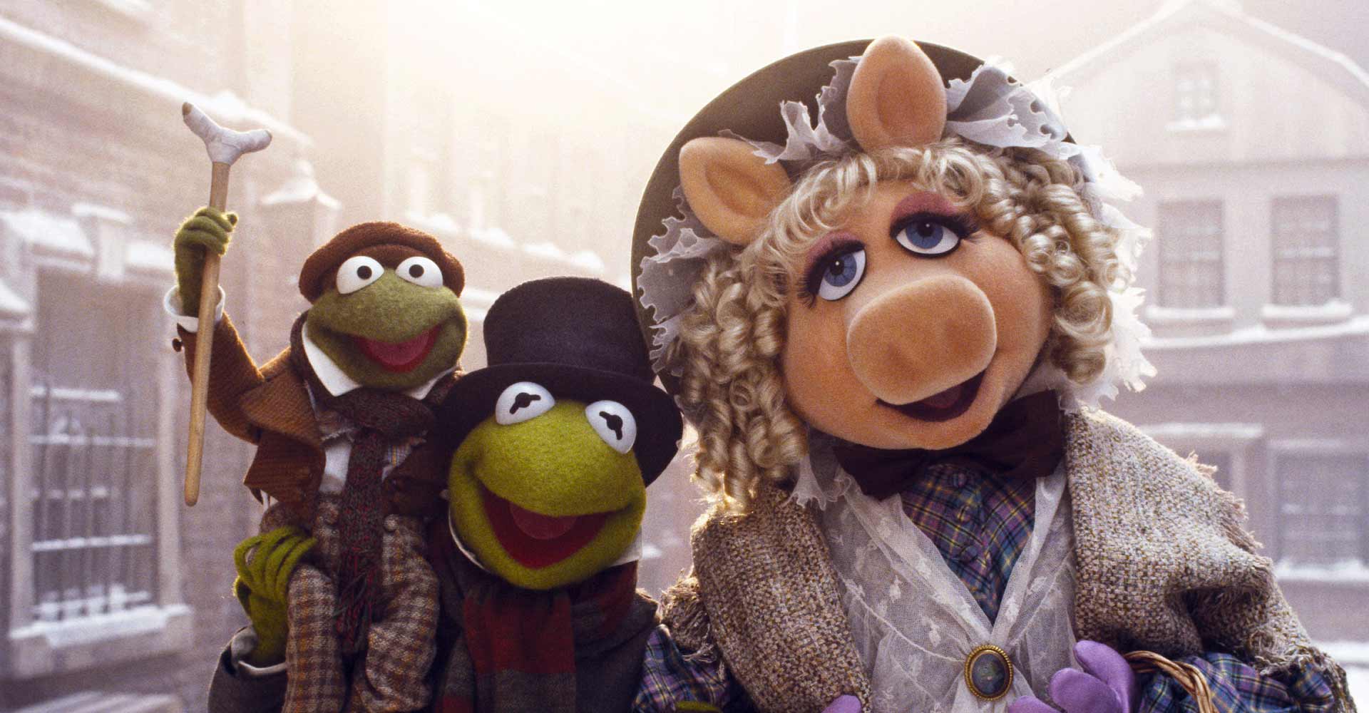 Muppet puppets of a pig, frog and others standing in snowy scene