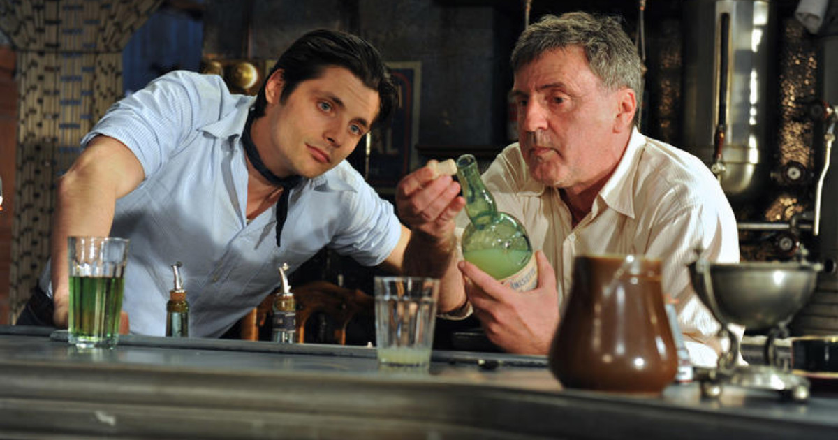 Young man and his father sitting at a table looking at something carefully